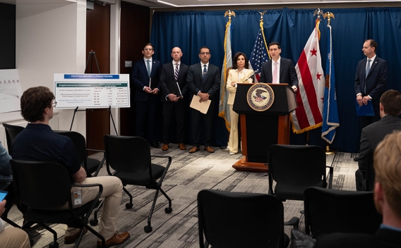 Matthew R. Galeotti delivers remarks from a podium at the United States Attorney’s Office for the District of Columbia. He is joined by Department of Justice and federal government officials.