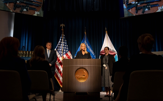 Attorney General Pamela Bondi delivers remarks from a podium at the Drug Enforcement Administration Headquarters. She is joined by DEA Acting Administrator Robert J. Murphy.